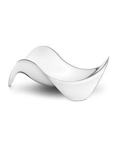 a white object with curved shapes on it's sides, sitting on a white surface