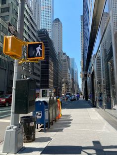 there is a yellow traffic light on the side of the street with buildings in the background