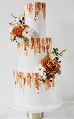 a three tiered cake with orange and white flowers