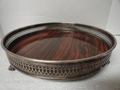 an ornate metal tray with wood inlays on the bottom and sides, sitting on a white surface