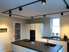 a modern kitchen with an island and black counter tops