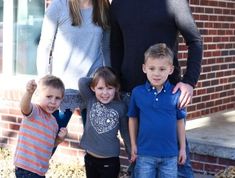 a family poses for a photo in front of a brick building