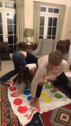 two people laying on top of a colorful rug