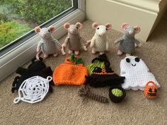 crocheted mice and pumpkins are on the floor next to a window sill