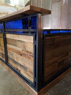 a wooden counter top sitting inside of a room next to a metal frame and blue glass window