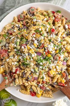 a bowl filled with pasta salad and topped with feta cheese, tomatoes, olives