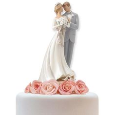 a bride and groom figurine on top of a wedding cake with pink roses