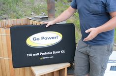 a man is standing next to a portable solar power box that has the words go power written on it