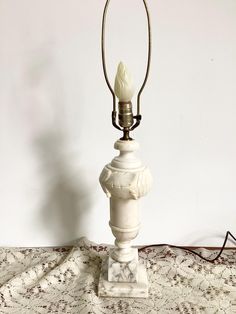 a white table lamp sitting on top of a rug