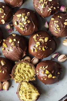 there are chocolate eggs with nuts and pistachios on the top one is cut in half