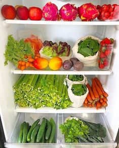 an open refrigerator filled with lots of fresh fruits and vegetables next to other produce items