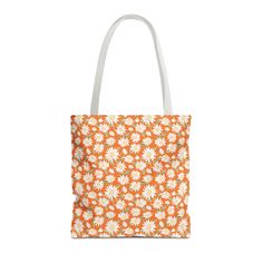 It's like tote bags in one. Choose which side to display based on your mood with this trendy, double-sided reversible tote bag in two different-sized floral prints.  A beautiful bold daisy print on one side and a small pretty daisy pattern on the other side. Originally hand-painted in watercolor for that one-of-a-kind artisan look, make a bold fashion statement with this floral daisy tote on an orange background.  Whether you're heading off to the beach, working at the coffee shop, or indulging in your favorite crafts, this retro floral bag is designed to meet all your needs with a touch of preppy style.  Crafted from polyester with double-stitched seams, cotton webbing straps with reinforced stitching, and non-woven laminate lining make for a high-end durable bag. Available in 3 sizes, th Reversible Tote Bag, Reversible Tote, Floral Bags, Daisy Pattern, Orange Background, Orange Bag, Daisy Print, Book Bag, Retro Floral