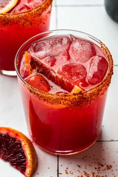 two glasses filled with blood orange margaritas and garnish