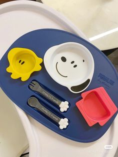 a child's tray with spoons, plates and utensils