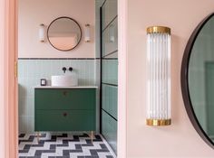 a bathroom with pink walls, green cabinets and black and white checkered flooring