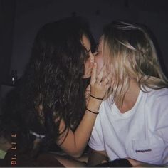 two women kissing each other while sitting down