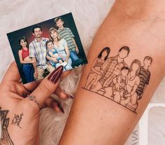 a woman holding up a small family photo with her hand on top of the arm