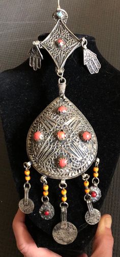 This impressive piece is unlike any I've ever had. Dating to the late 19th century to early 1900s, this is a lovely example of beautiful handmade mideastern silver filigree, and it appears to be a one-of-a-kind artist piece. From a local estate, it appears to be Yemeni silver and boasts coral and turquoise colored stones. They are polished and I believe the ones set into the silver are actual stones, while the orange dangling beads appear to be glass. The silver seems to be a low grade silver, p Decatur Ga, Antique Filigree, Hamsa Pendant, Colored Stones, Hand Of Fatima, Ancient Symbols, Vintage Turquoise, Silver Filigree, Cuff Bangles