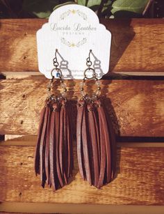 "Super soft deerskin leather tassels wrapped in antique brass wire with antique brass beads and 12 faceted Mystic Agate gemstones in the color champagne.  Measurements: about 4\" including ear wires Choose from one of our 6 beautiful deerskin colors. All of our findings and ear wires are antique brass that are both lead and nickel free for sensitive ears!    When you order from Lucida, you will receive quality, one-of-a-kind jewelry to wear and share for years.  I've spent many hours creating every piece, turning classic shapes into perfect styles, in order to design a truly special, sophisticated collection just for you! About the products we use: Beautiful, supple and strong \"lace\" made of deerskin Our findings are antique brass that are free of nickel and lead for sensitive ears!" Artisan Brown Jewelry With Tassels, Brown Tassel Jewelry For Festivals, Bohemian Hand Wrapped Brown Earrings, Bohemian Brown Hand Wrapped Earrings, Bohemian Brown Hand-wrapped Earrings, Adjustable Brown Earrings With Beaded Fringe, Color Champagne, Deer Skin, Lace Making