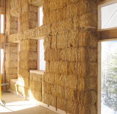 an unfinished room with hay bales and windows