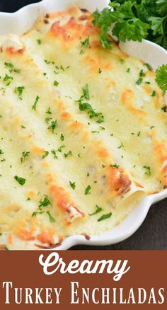 creamy turkey enchiladas in a white dish with parsley on the side