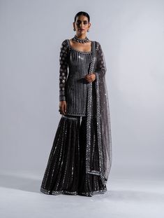 Editor's Note Featuring a charcoal grey heavy embellished mirror and multi thread work sharara with kurta and dupatta Fabric: Sharara: georgette, dupatta: net, kurta: georgette Color: Charcoal grey Component: Sharara, kurta and dupatta Sleeve type: Full Occasion: Festive Care: Dry Clean Only About the Designer Vvani by Vani Vats- an Indian ethnic women’s wear label. It is a depiction of the royal and intricate handcrafted embroideries in unconventional designs. Grey Sharara, Black Sharara Suit, Black Sharara, Tassels Dupatta, Vani Vats, Kurta And Dupatta, Sheer Dupatta, Full Sleeves Design