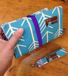 a person holding onto a blue and white bag with purple trimmings on it