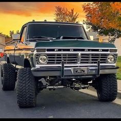 an old truck is parked on the side of the road in front of a house