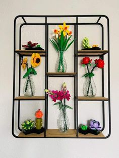 a shelf with vases and flowers on top of it, hanging from the wall