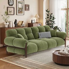 a living room with green couches and pictures on the wall