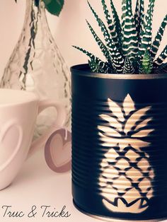 a potted plant sitting on top of a table next to a cup and saucer