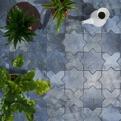 an overhead view of a tiled floor with potted plants