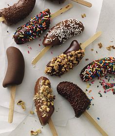 an image of chocolate covered donuts on sticks with sprinkles and nuts