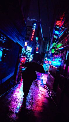 a person with an umbrella walking down the street in the rain at night, illuminated by neon signs