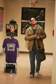 a man walking down a hallway next to a mannequin