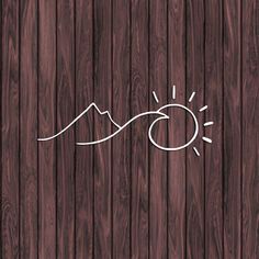 a wooden background with the sun and mountains drawn in white ink on wood planks