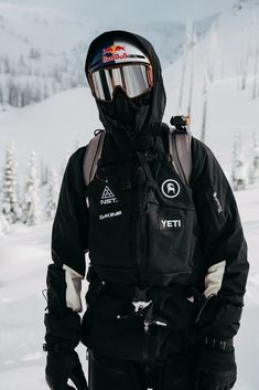 a man standing on top of a snow covered slope wearing skis and goggles