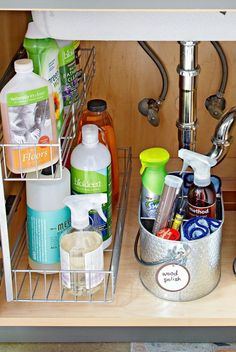 an organized kitchen sink with soap, shampoo and lotion in the bottom drawer