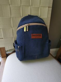 "Cute Denim Backpack. From daily life to starting your school day, this Denim Backpack has you covered. A large zipped compartment offers room for books and for Tablets, Phones, and more necessary accessories for daily commuting and going to school. There is an interior pocket that is zippable to help keeping electronics and small essentials stored. Product Size:  Length 24cm (9\"), Height 30cm (11\"), Width 14cm (5 1/2\")." Recycled Jeans Bag, Jeans Backpack, Denim Backpack, Denim Crossbody, Recycled Jeans, Crossbody Bags For Travel, Going To School, Kids Backpack, No Waste