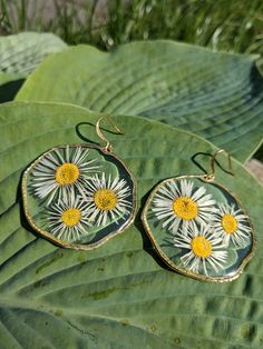 Naturally pressed and preserved Daisy flower earrings. Grown in my garden, daisies symbolise purity, innocence, new beginnings, joy and cheerfulness.  Hooks and bezels are 18k gold plated, hypoallergenic and nickel free.  Gift for someone special or a treat for yourself that no one else will own. With love, Maki Garden Daisies, Heather Flower, Glitter Leaves, Oval Earrings, Oval Earring, Enamel Flower, Lovely Earrings, Floral Earrings, Flower Jewellery