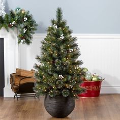 a small christmas tree in a pot on the floor