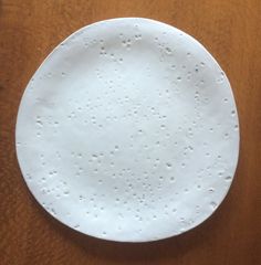 a white plate sitting on top of a wooden table