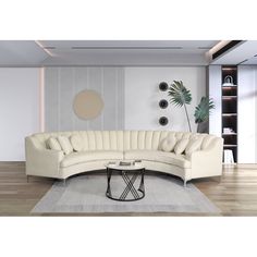 a white sectional couch sitting on top of a wooden floor next to a coffee table