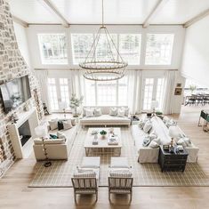 an aerial view of a living room with white couches, chairs and coffee table