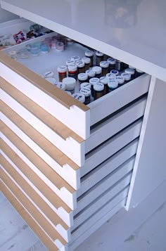 an open drawer in a cabinet filled with bottles