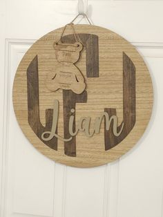 a wooden sign that says i am with a teddy bear hanging from the front door