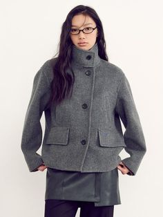 This coat with cropped length features a refreshing cropped length and a signature cocoon fit silhouette, perfect for exuding a casual yet feminine vibe.- Made of premium cashmere processed wool material- High-neck stand collar to add appeal to the item- Pocket details with blue embroidery Short Winter Coat, Winter Coat Short, Grey Coat, Blue Embroidery, Short Coat, Pocket Detail, Stand Collar, Winter Coat, High Neck