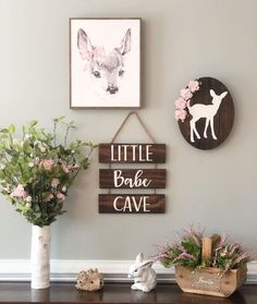 a wooden sign that says little bake cave next to two vases with flowers