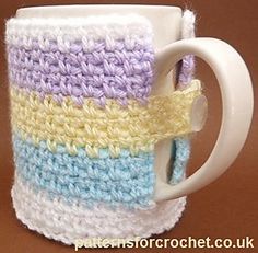 a crocheted coffee cup with a handle on the inside is shown in blue, yellow and white