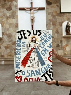 a man holding up a sign in front of a cross